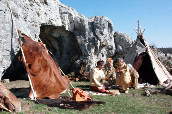 Steinzeitfamilie vor Höhle