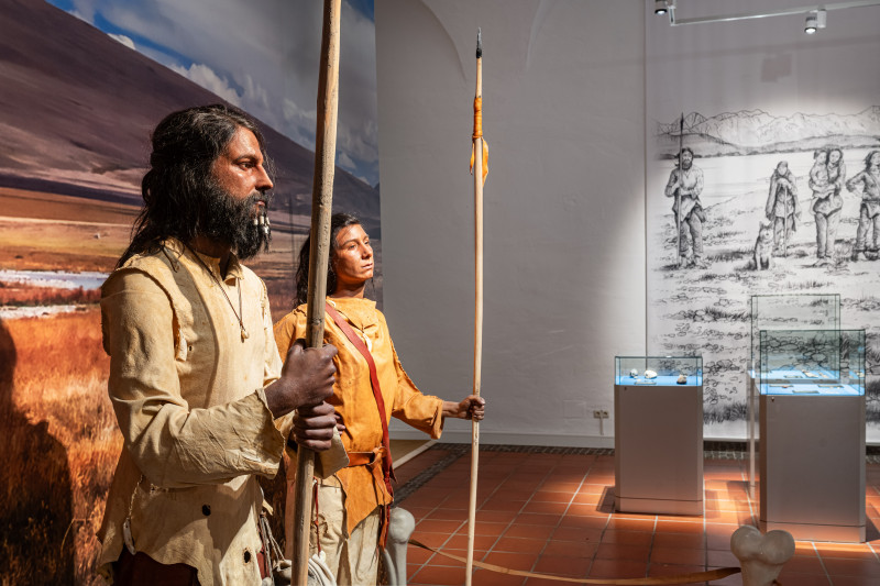 Die Ausstellung zeigt Nachbildungen einer Eiszeit-Frau und eines Eiszeit-Mannes mit originalgetreuer Kleidung und Speeren