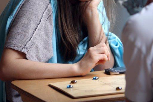 Mädchen spielt römisches Mühlespiel